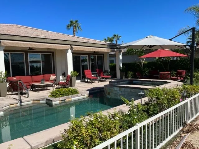 a view of a swimming pool with chairs in patio