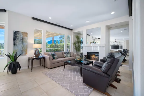 a living room with furniture large window and a fireplace