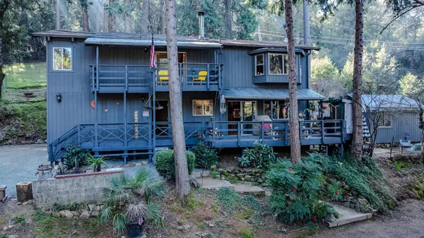 a front view of a house with plants and trees
