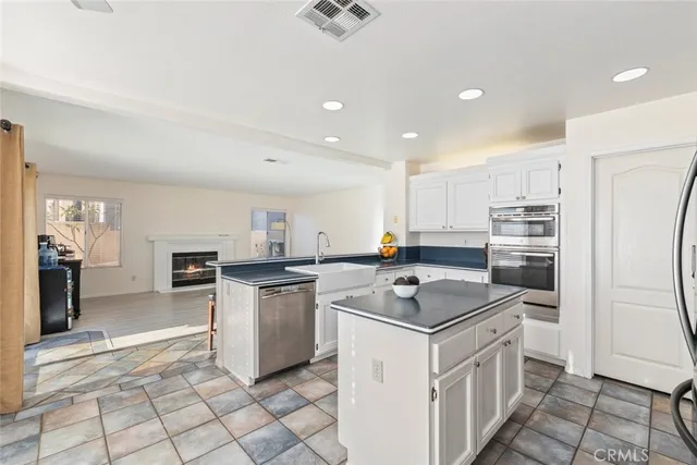 a kitchen with a sink a counter top space and stainless steel appliances