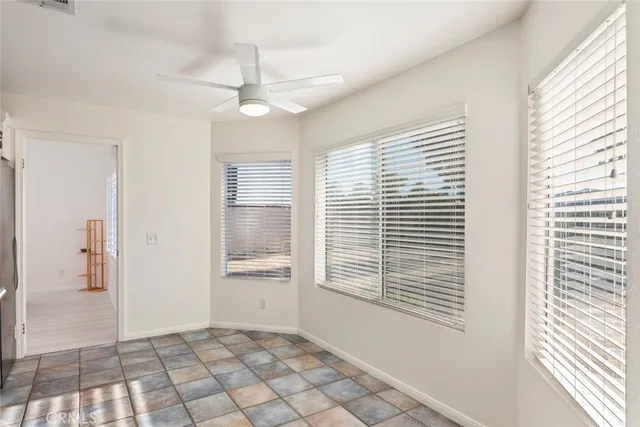 a view of an empty room with a window and a kitchen