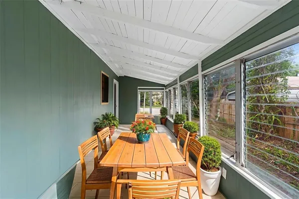a view of a patio with table and chairs with wooden floor and fence