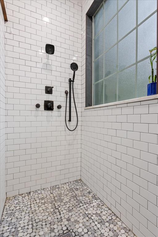 5616 Landsdown Drive Waco, TX 76708 - Photo 18 of 33 Shower featuring white subway tile walls and a pebble stone floor