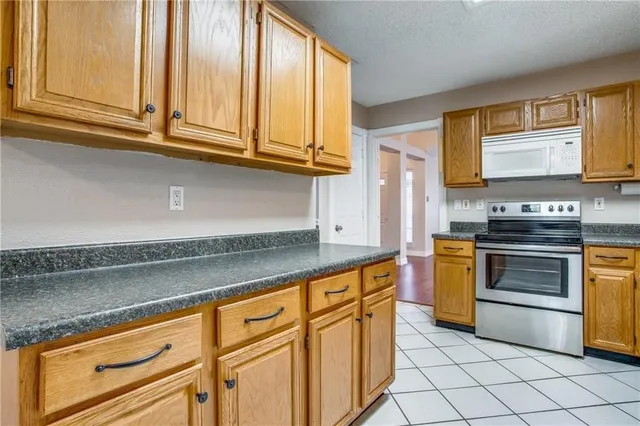 a kitchen with granite countertop cabinets stainless steel appliances and a sink