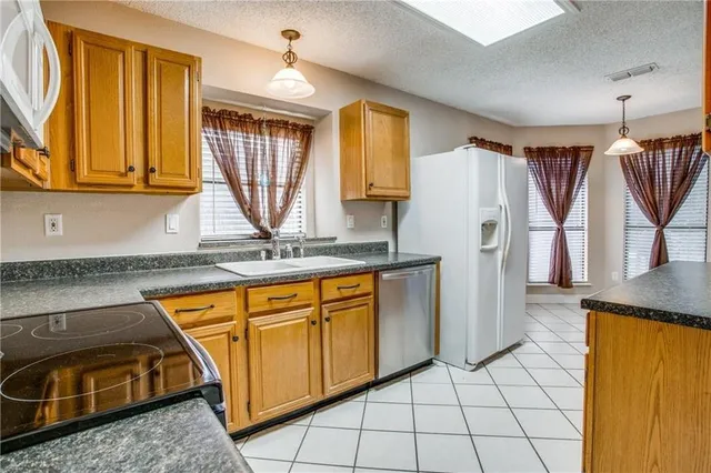 a kitchen with stainless steel appliances granite countertop a stove a sink and a refrigerator