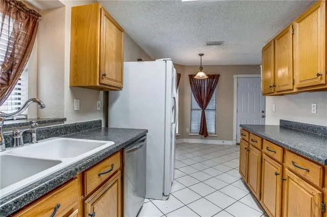 a kitchen with stainless steel appliances granite countertop a sink and a refrigerator