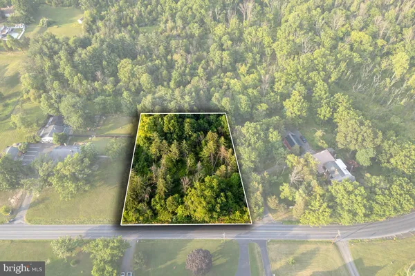 an aerial view of residential houses with outdoor space and trees