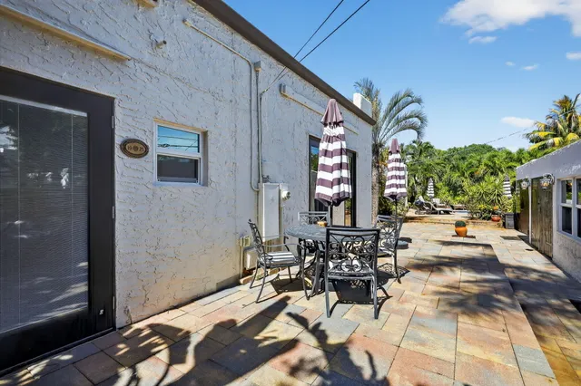 a view of a patio with a table and chairs under an umbrella