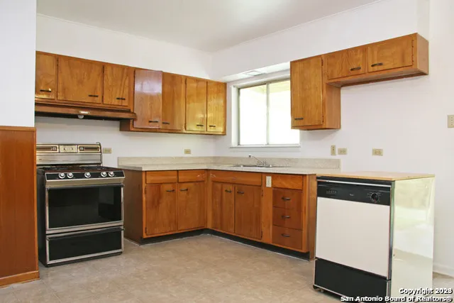 a kitchen with stainless steel appliances granite countertop a stove a sink and a microwave