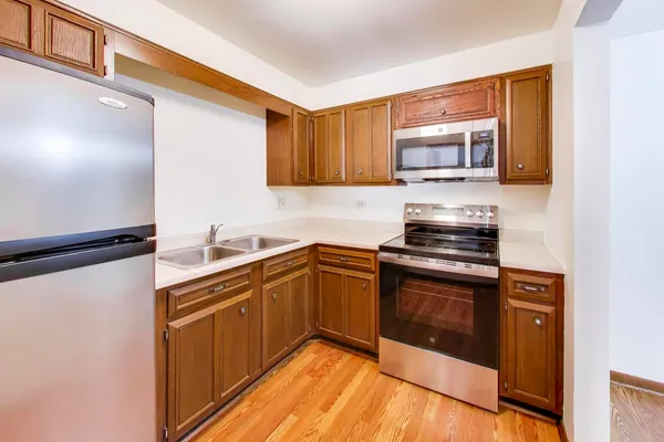 a kitchen with stainless steel appliances granite countertop a stove a sink and a microwave