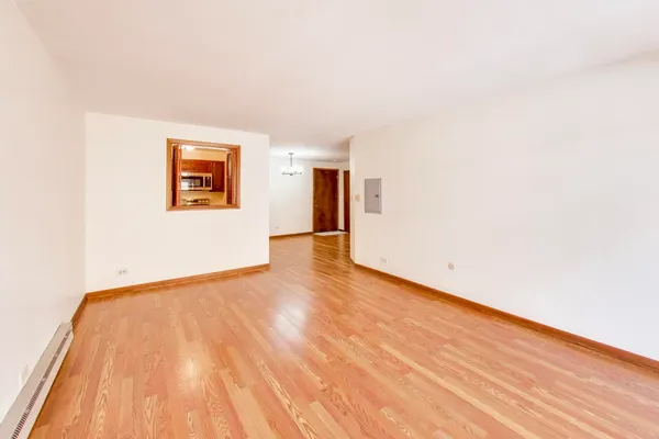 a view of an empty room with wooden floor