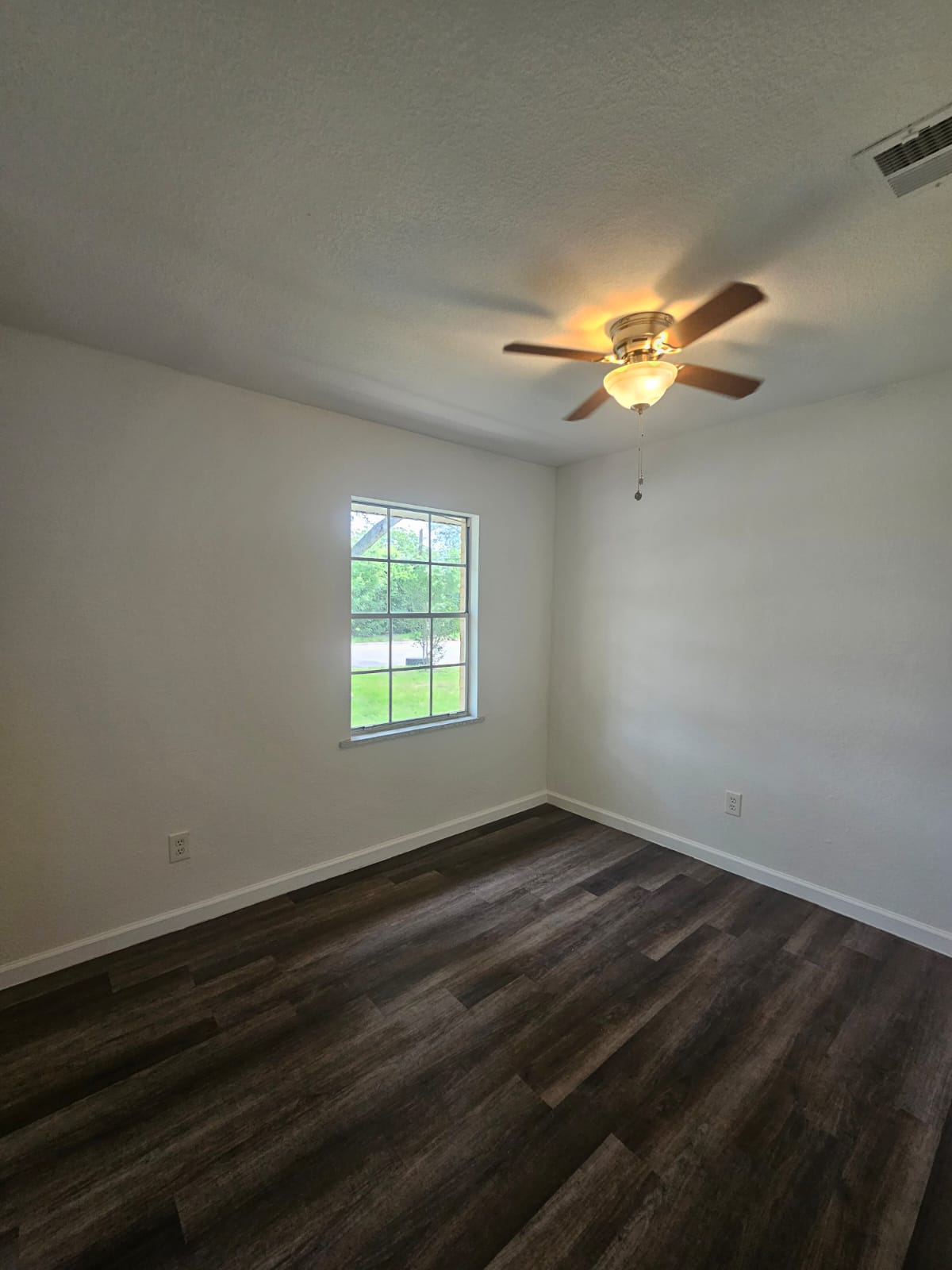 1401 Trinity Street Lockhart, TX 78644 - Photo 21 of 31 Room with dark wood-finish flooring, white baseboards, and a window with a white frame