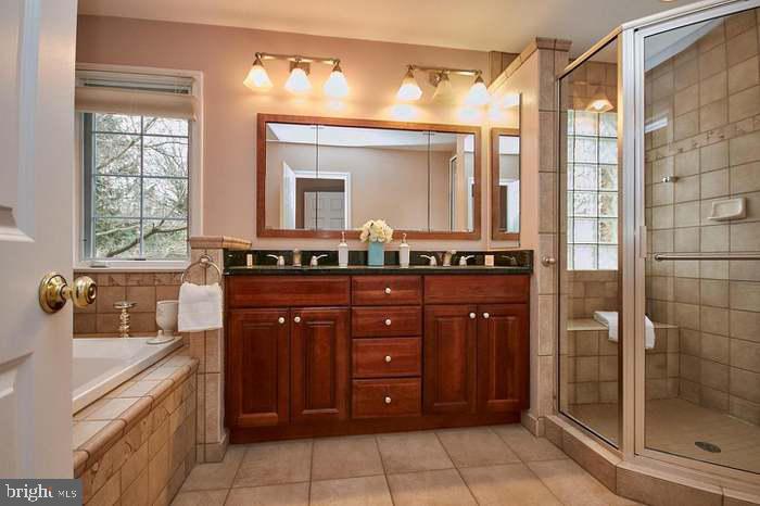 1006 Kimberwicke Road McLean, VA 22102 - Photo 22 of 42 a bathroom with a granite countertop sink a mirror and a shower