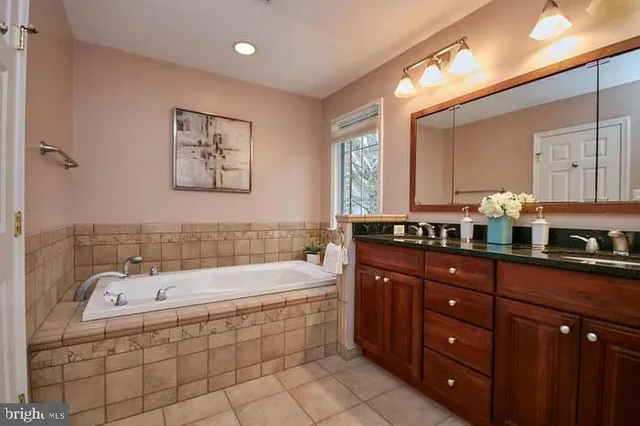 a bathroom with a tub sink and mirror