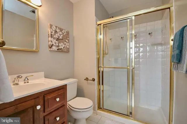 a bathroom with a shower sink vanity mirror and toilet