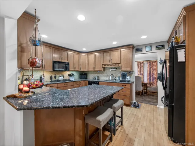 a kitchen with granite countertop a table chairs microwave and cabinets