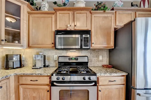 a stove top oven sitting inside of a kitchen and granite counter tops
