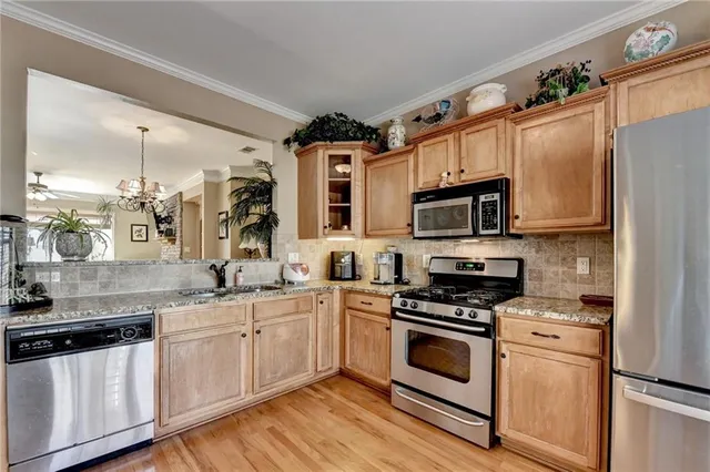 a kitchen with stainless steel appliances granite countertop a stove a sink and a microwave