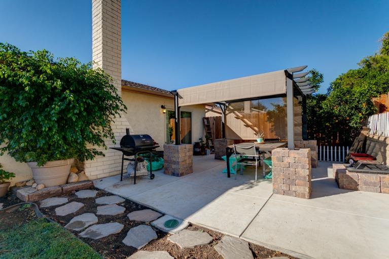 637 Thomas Street Oak View, CA 93022 - Photo 22 of 30 a view of a patio with table and chairs potted plants and a palm tree