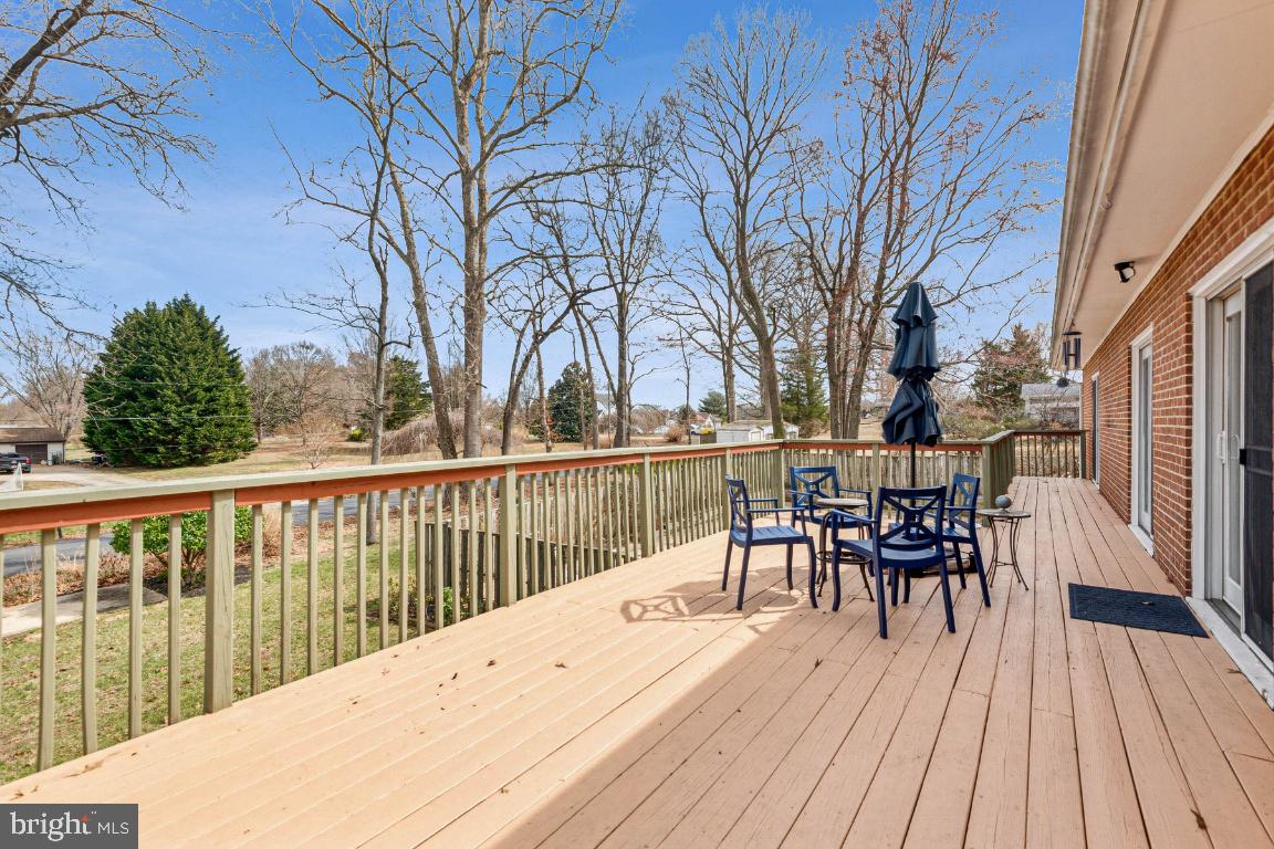 11213 Oakwood Drive Dunkirk, MD 20754 - Photo 41 of 48 a view of a roof deck with table and chairs floor to ceiling window with wooden floor