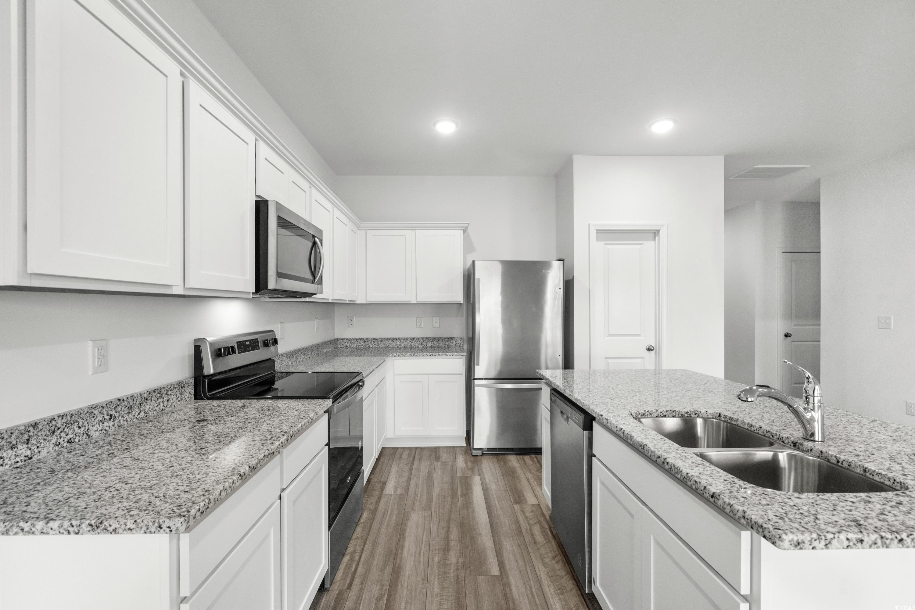 443 Castillo Drive Longs, SC 29568 - Photo 10 of 32 Kitchen featuring stainless steel appliances, a center island with sink, light stone counters, white cabinets, and dark wood-style flooring