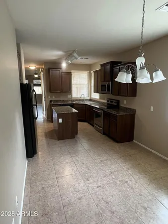 a large kitchen with granite countertop a refrigerator and a sink