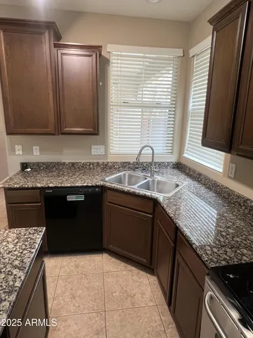 a bathroom with a granite countertop sink a toilet and a mirror
