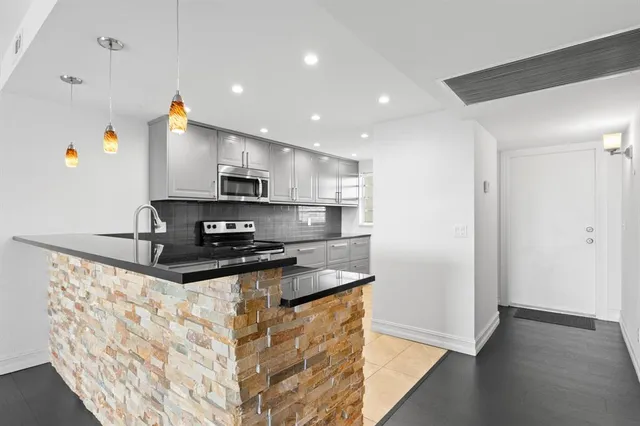 a kitchen with stainless steel appliances granite countertop a sink stove and refrigerator