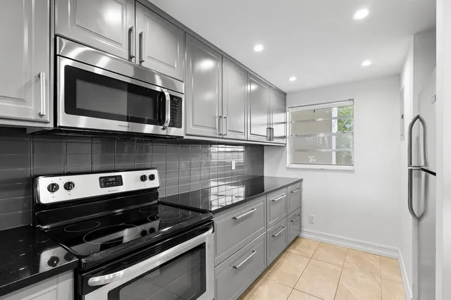 a kitchen with stainless steel appliances granite countertop a stove and a microwave