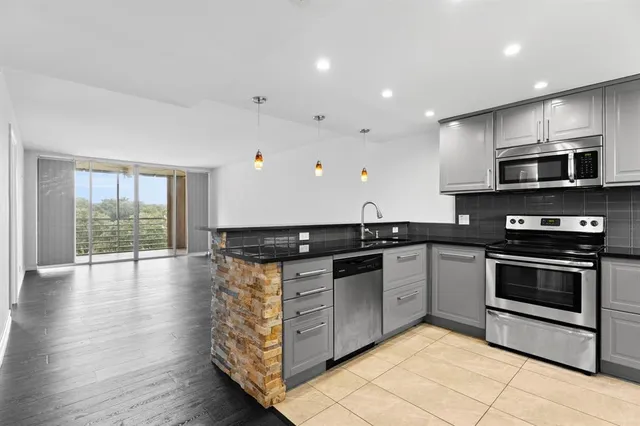 a kitchen with stainless steel appliances granite countertop a stove and a sink