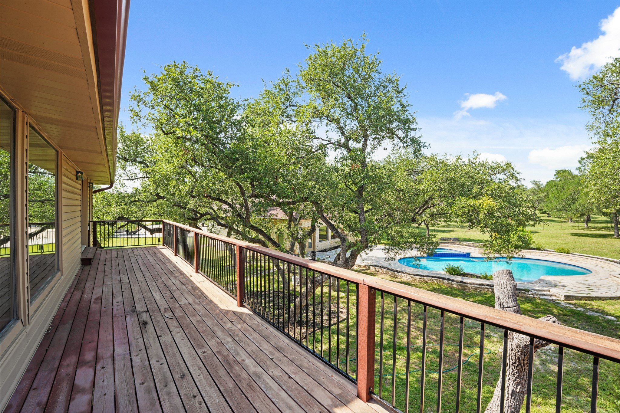 176 Logan Ranch Road Georgetown, TX 78628 - Photo 10 of 38 Wooden terrace with an outdoor pool and view of scattered trees with access from primary bedroom and game room