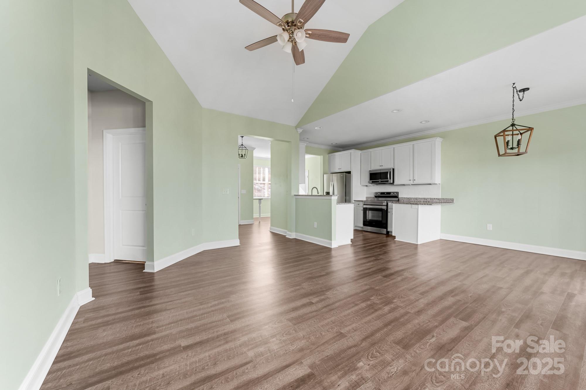 7617 Red Robin Trail Denver, NC 28037 - Photo 14 of 38 a view of a kitchen with a fridge wooden floor and a kitchen