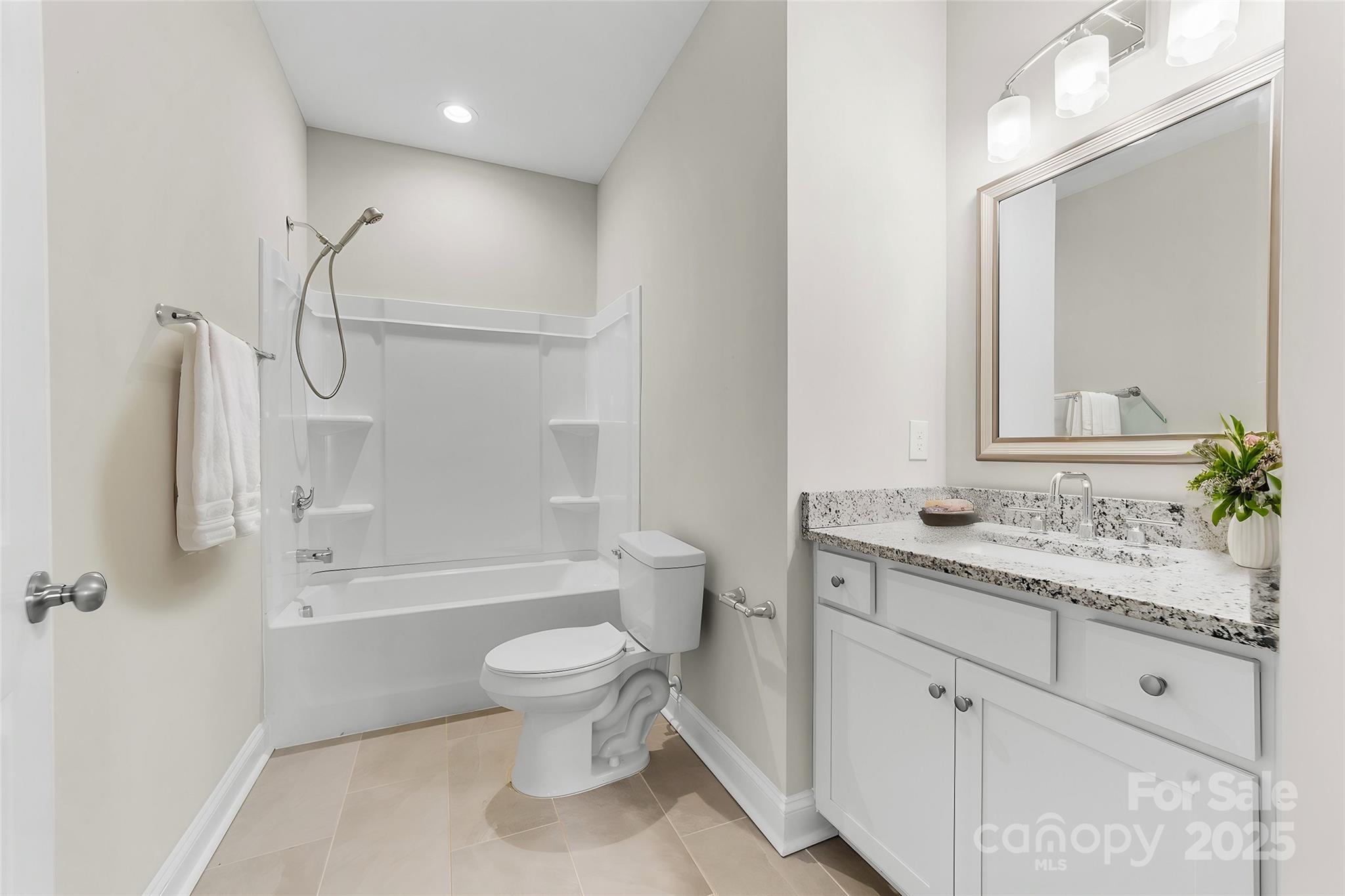 7617 Red Robin Trail Denver, NC 28037 - Photo 26 of 38 a bathroom with a granite countertop sink a toilet and a bathtub