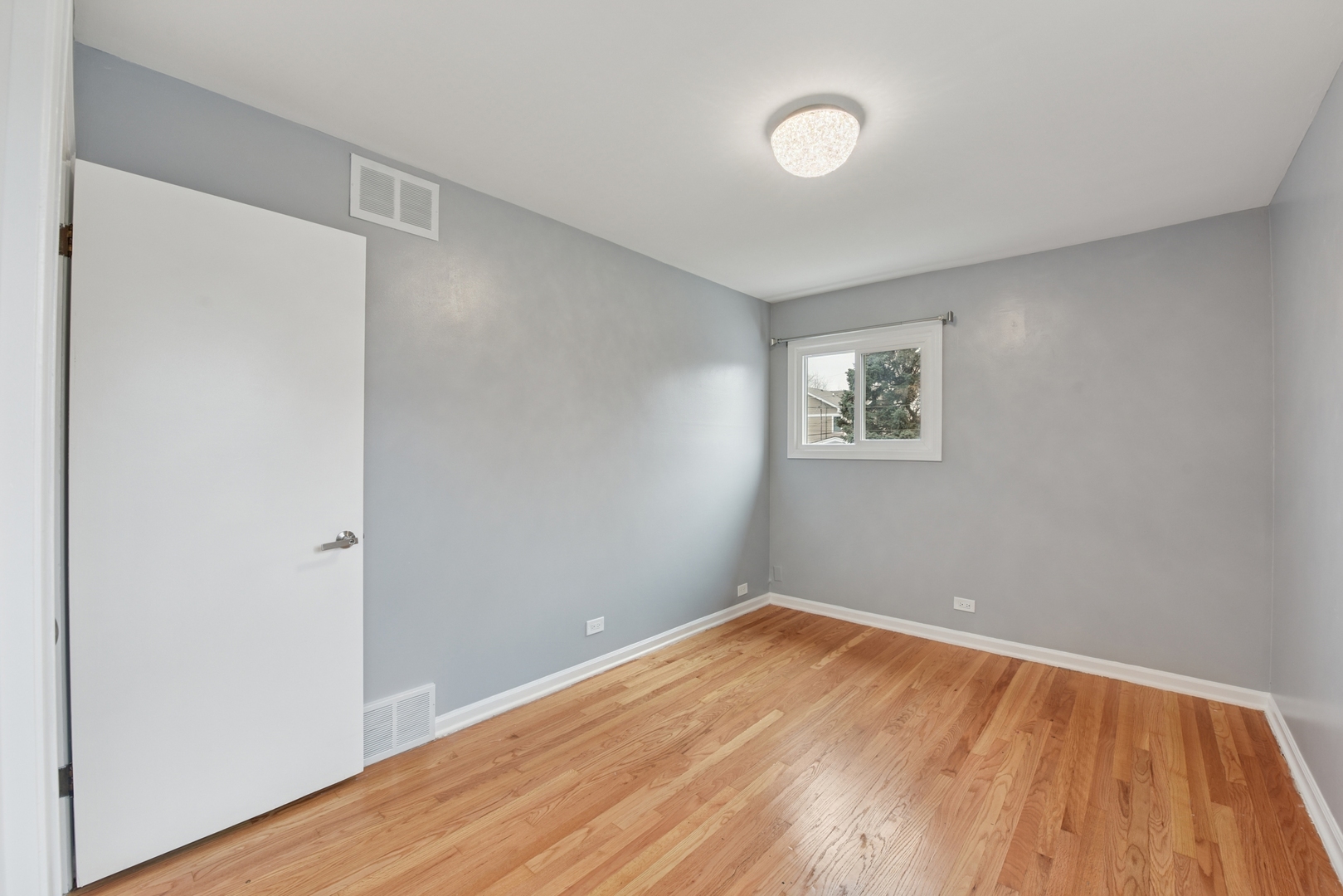 5829 Madison Street Morton Grove, IL 60053 - Photo 22 of 28 a view of a room with wooden floor and white walls