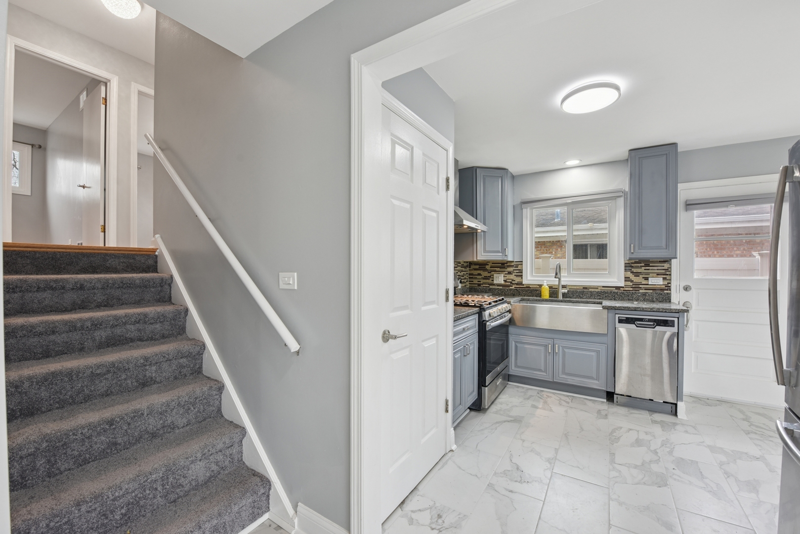 5829 Madison Street Morton Grove, IL 60053 - Photo 5 of 28 a kitchen with white cabinets and stainless steel appliances