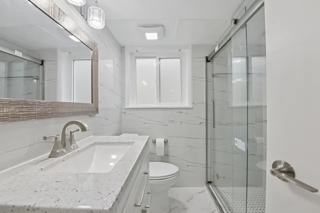 a bathroom with a sink a toilet and shower