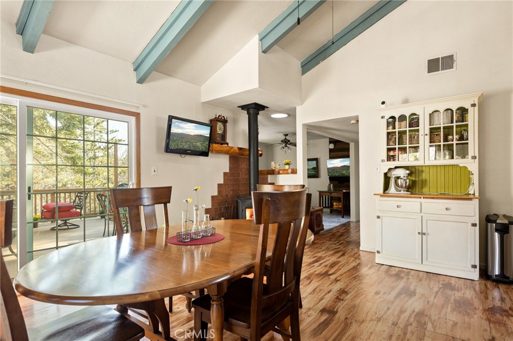 337 Lookout Drive Twin Peaks, CA 92391 - Photo 4 of 32 a kitchen with stainless steel appliances granite countertop a stove a refrigerator a dining table and chairs with wooden floor