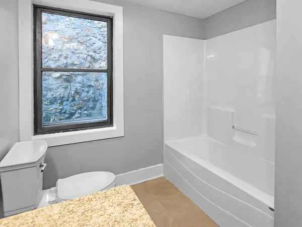 a view of an empty room with closet and a window