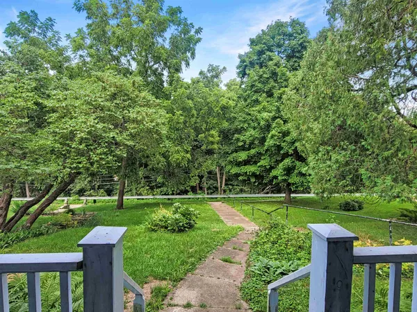 a kitchen with stainless steel appliances granite countertop a refrigerator a stove top oven a sink and dishwasher with wooden floor