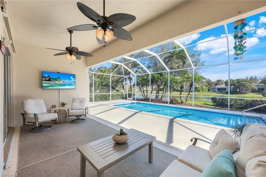 3108 Dominica Way Naples, FL 34119 - Photo 24 of 39 Screened lanai featuring a swimming pool, covered patio, and water frontage