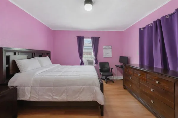 a bedroom with a bed and wooden floor