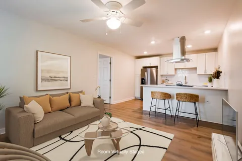 a living room with furniture and kitchen view