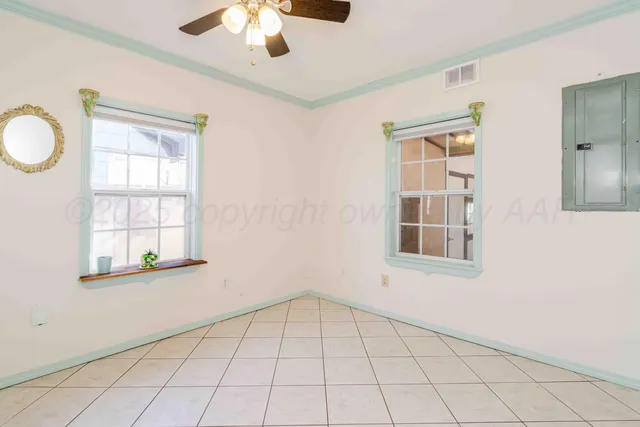 an empty room with windows and ceiling fan