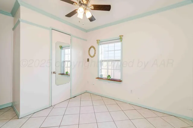 an empty room with windows and fan