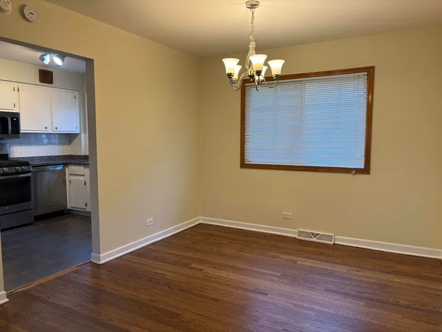 a view of a kitchen with a sink wooden floor and a chandelier