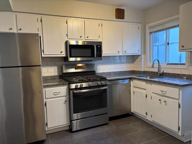 a kitchen with cabinets stainless steel appliances and a sink
