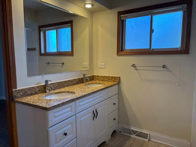 a bathroom with a granite countertop sink and a mirror