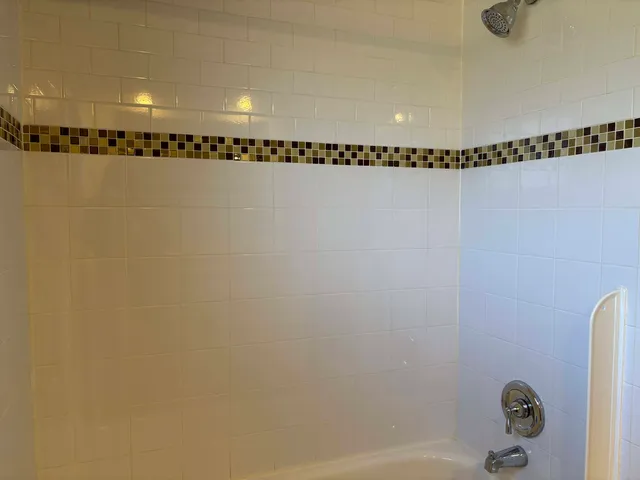 a bathroom with a shower and trees in the background