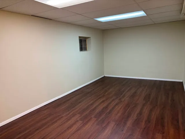 a view of a room with wooden floor and white walls