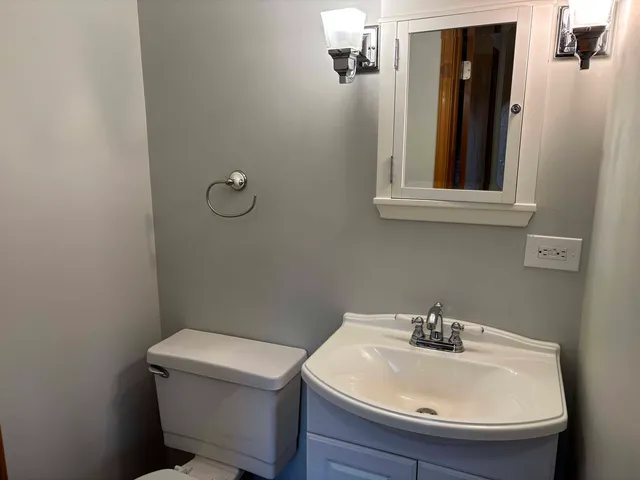 a bathroom with a sink a toilet and mirror